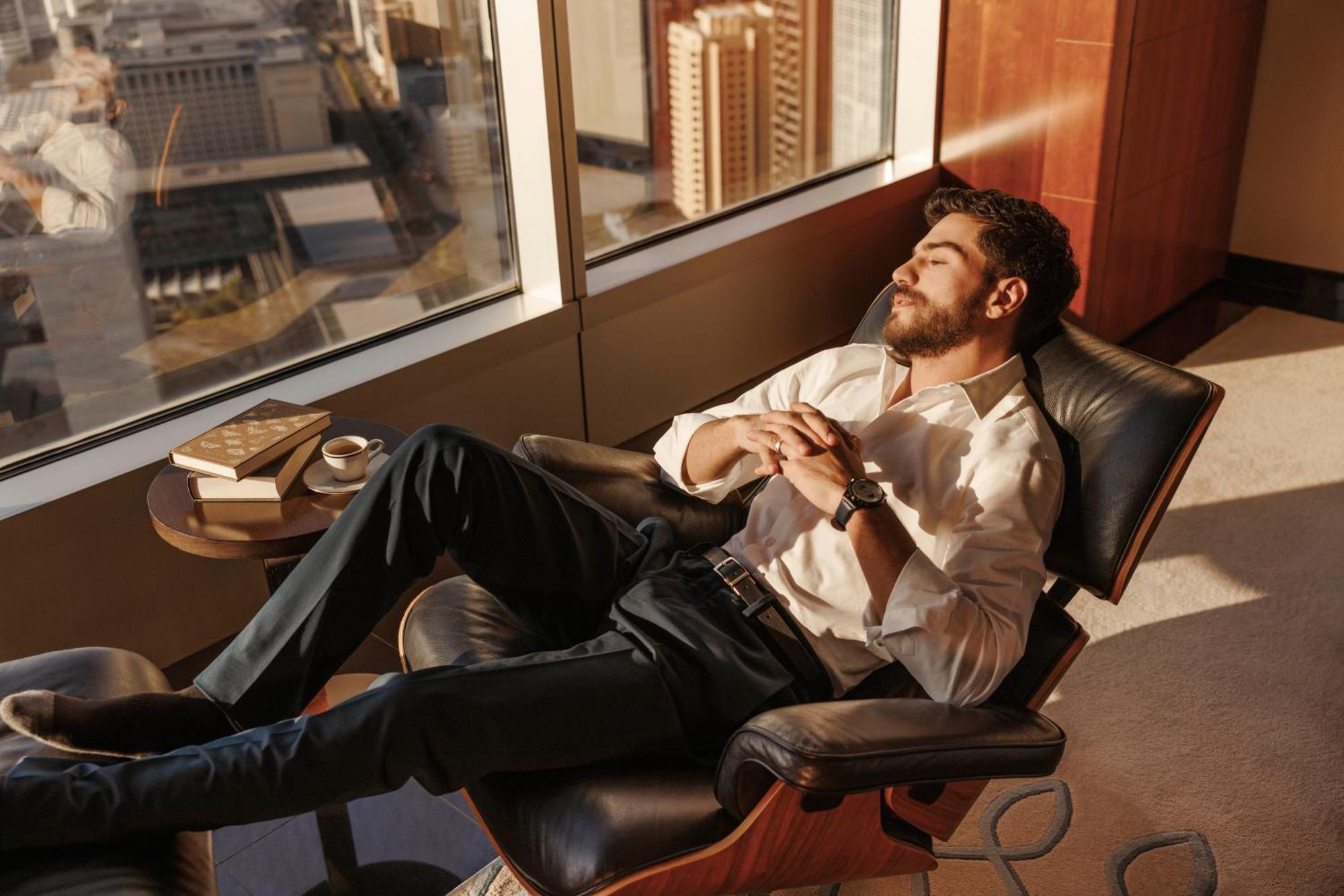 Jumeirah Emirates Towers Dubai Exterior photo A man relaxing in a chair