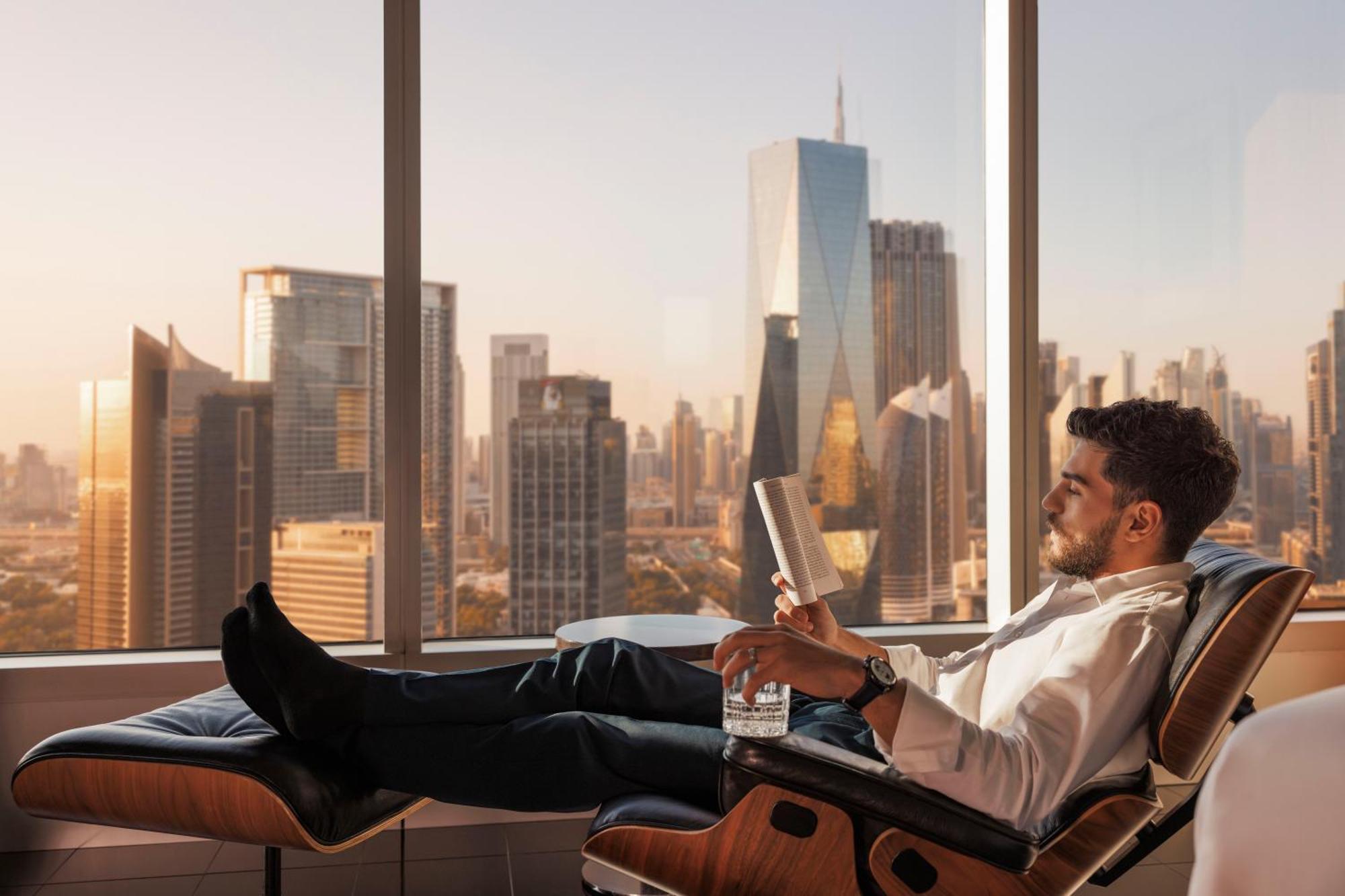 Jumeirah Emirates Towers Dubai Exterior photo A man relaxing in a chair